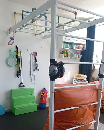 Sala de psicomotricidade com estrutura de escalada e colchão de proteção